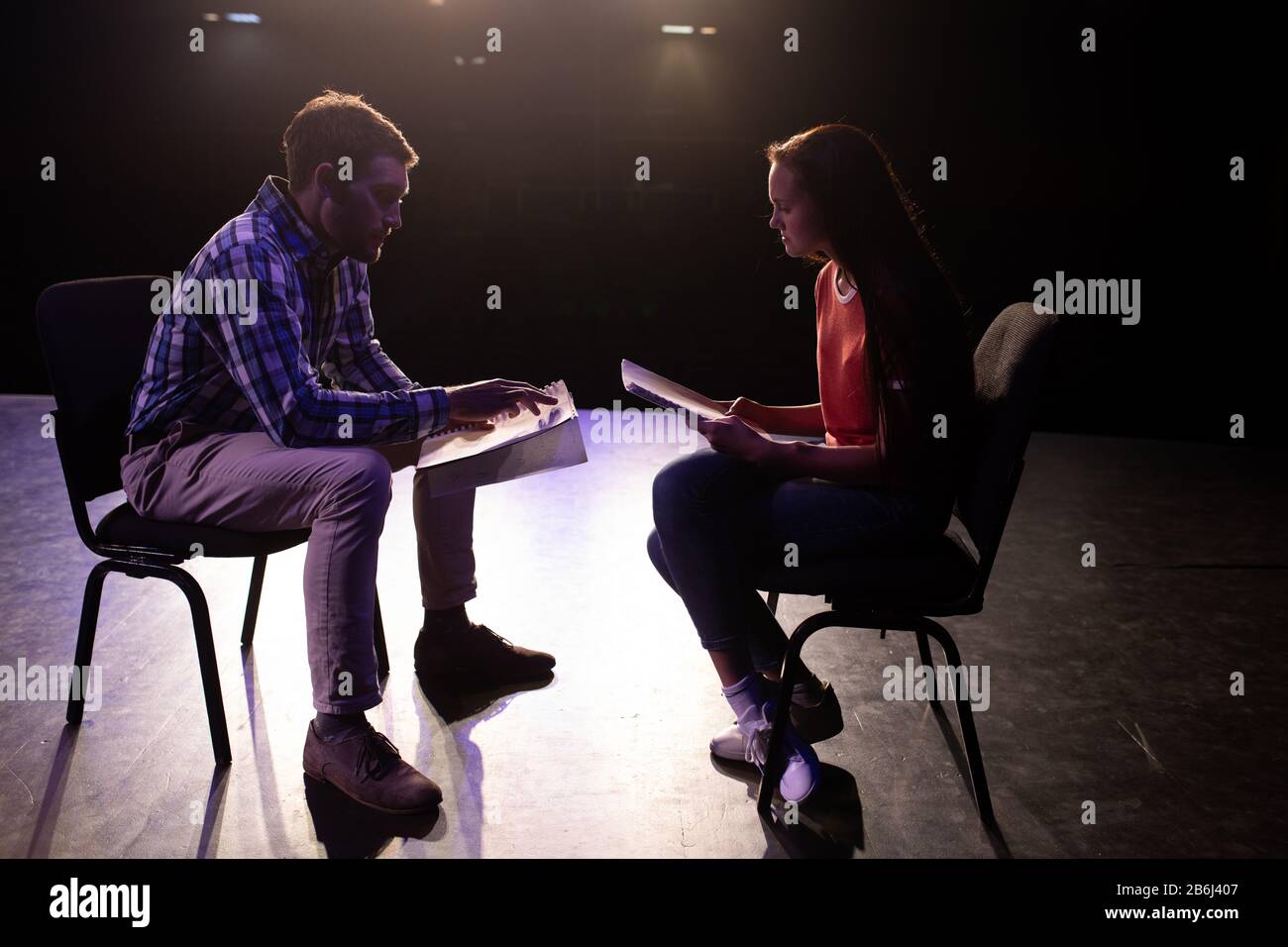 Side view of student and teacher practicing in a theater Stock Photo