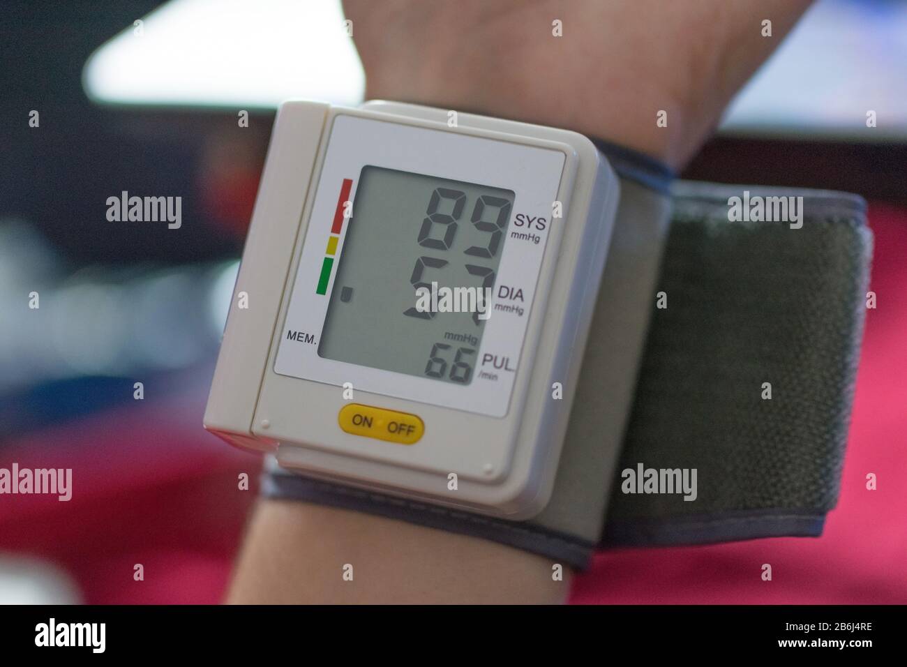 Blood pressure monitor on hand showing low or normal blood pressure ...