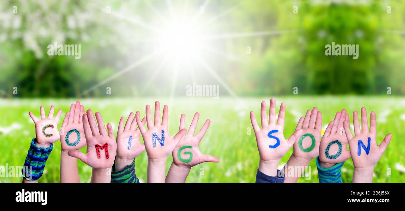 Children Hands Building Word Coming Soon, Grass Meadow Stock Photo - Alamy