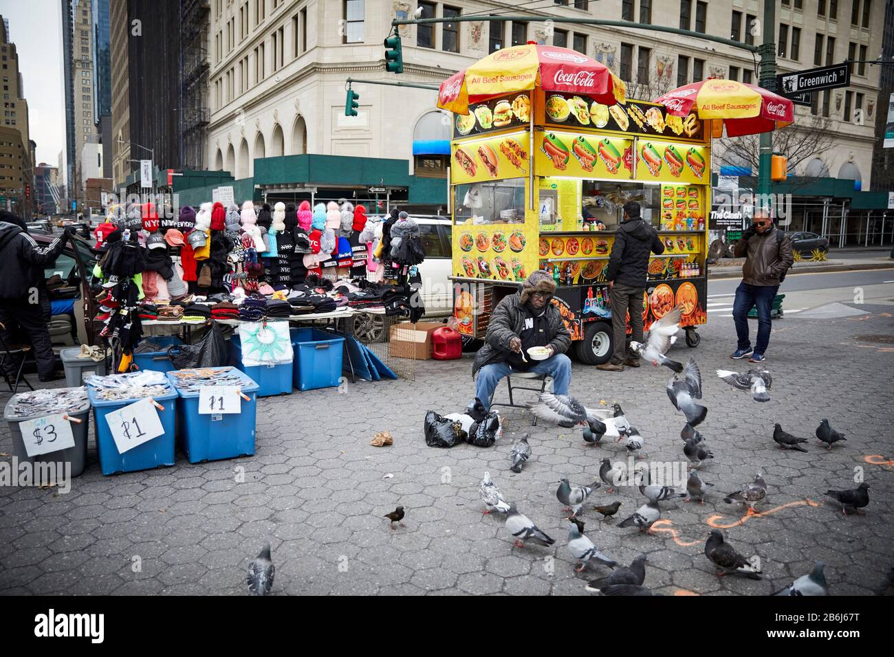 New York city Manhattan Battery Park area market street trader feeding the pigeons Stock Photo