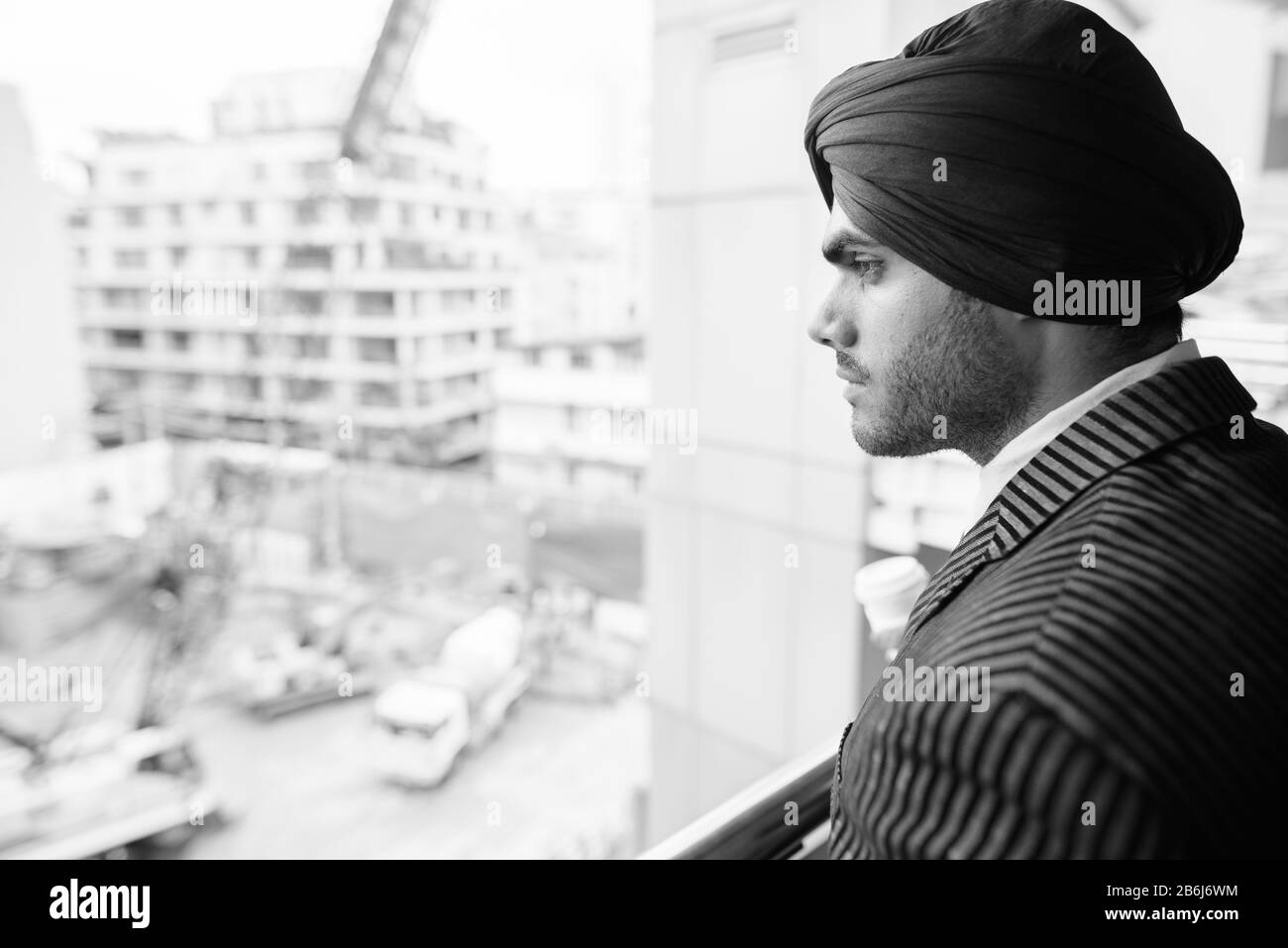 Young handsome Indian Sikh businessman against view of construction site Stock Photo