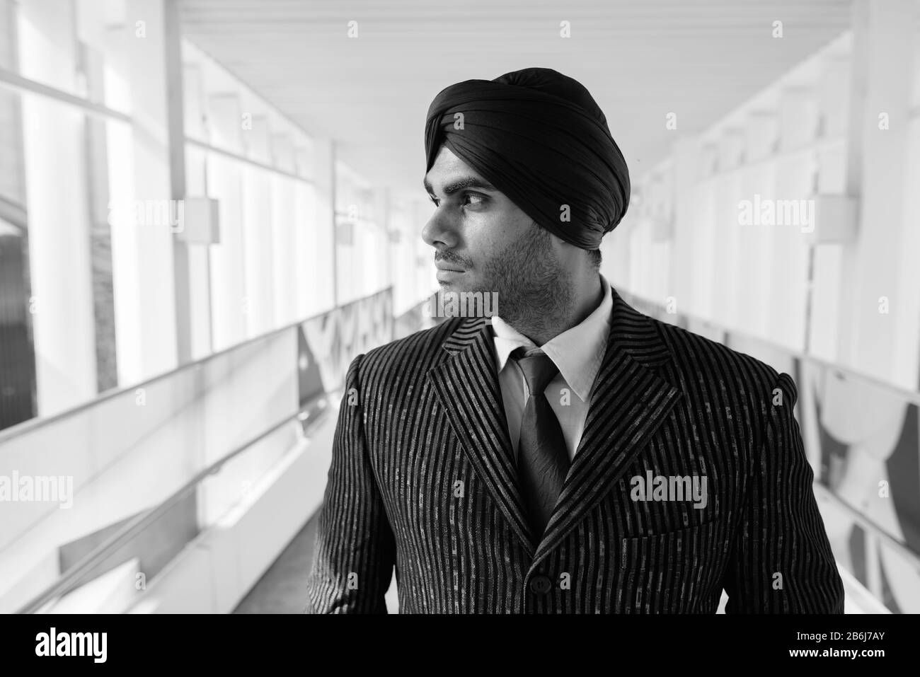 Young handsome Indian Sikh businessman thinking in the city Stock Photo