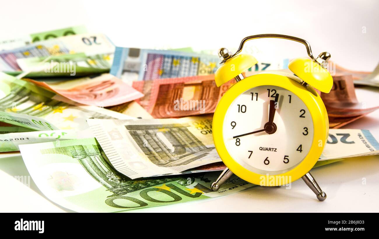 Alarm clock with paper euro money 10, 20, 50, 100, alarm clock on  banknotes, time is money Stock Photo - Alamy