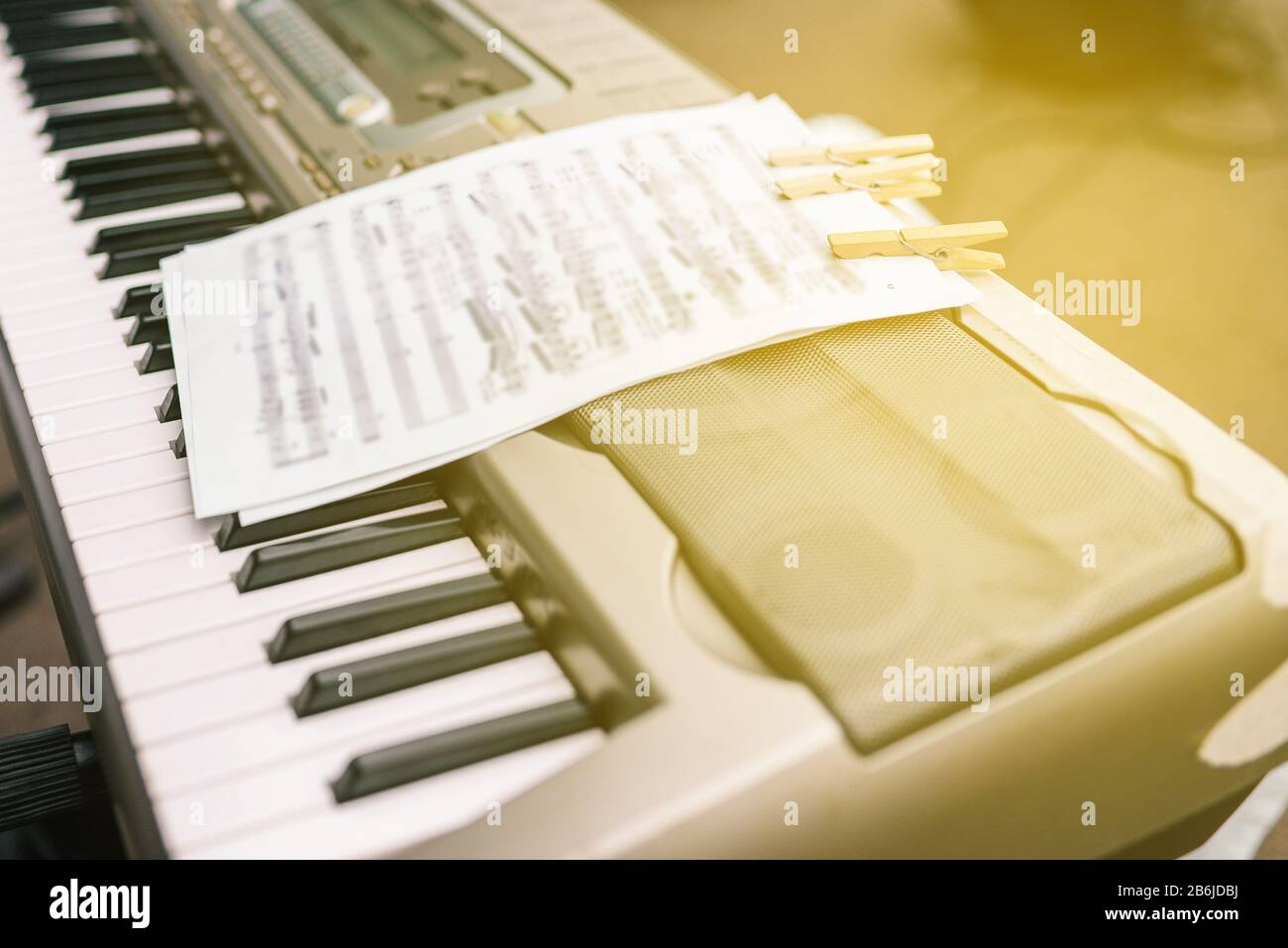 Musical synthesizer with a white sheet of paper with written notes. Street concert of musicians. Electronic keyboard musical instrument Stock Photo