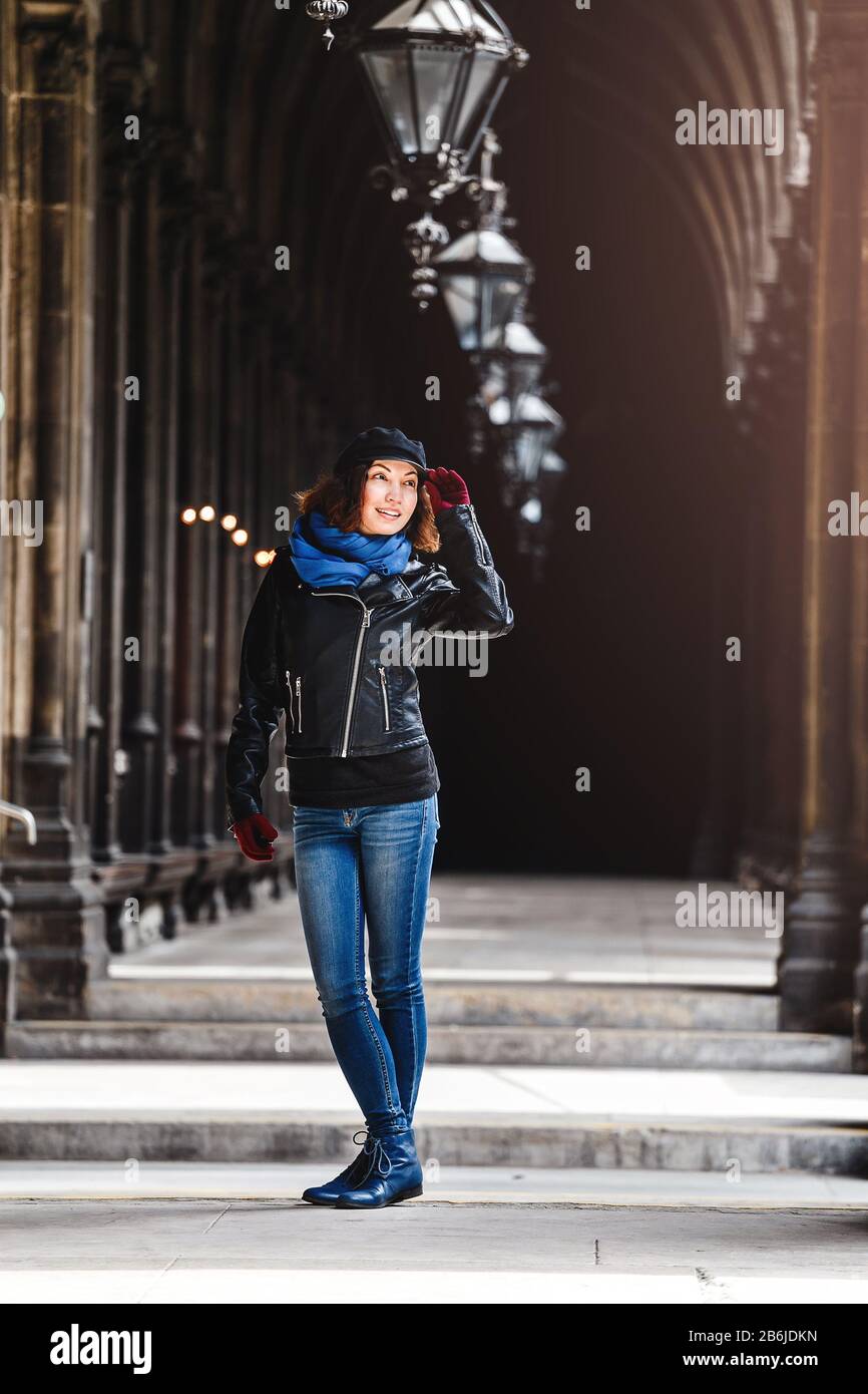 A woman in a leather jacket posing in a Gothic old corridor Stock Photo