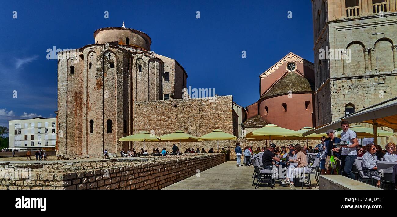 Zadar, Dalmatia province, Croatia, Apse of the Church of San Donato next to the bell tower of Santa Anastasia, tourists quench their thirst on the terraces of the Roman Forum Stock Photo