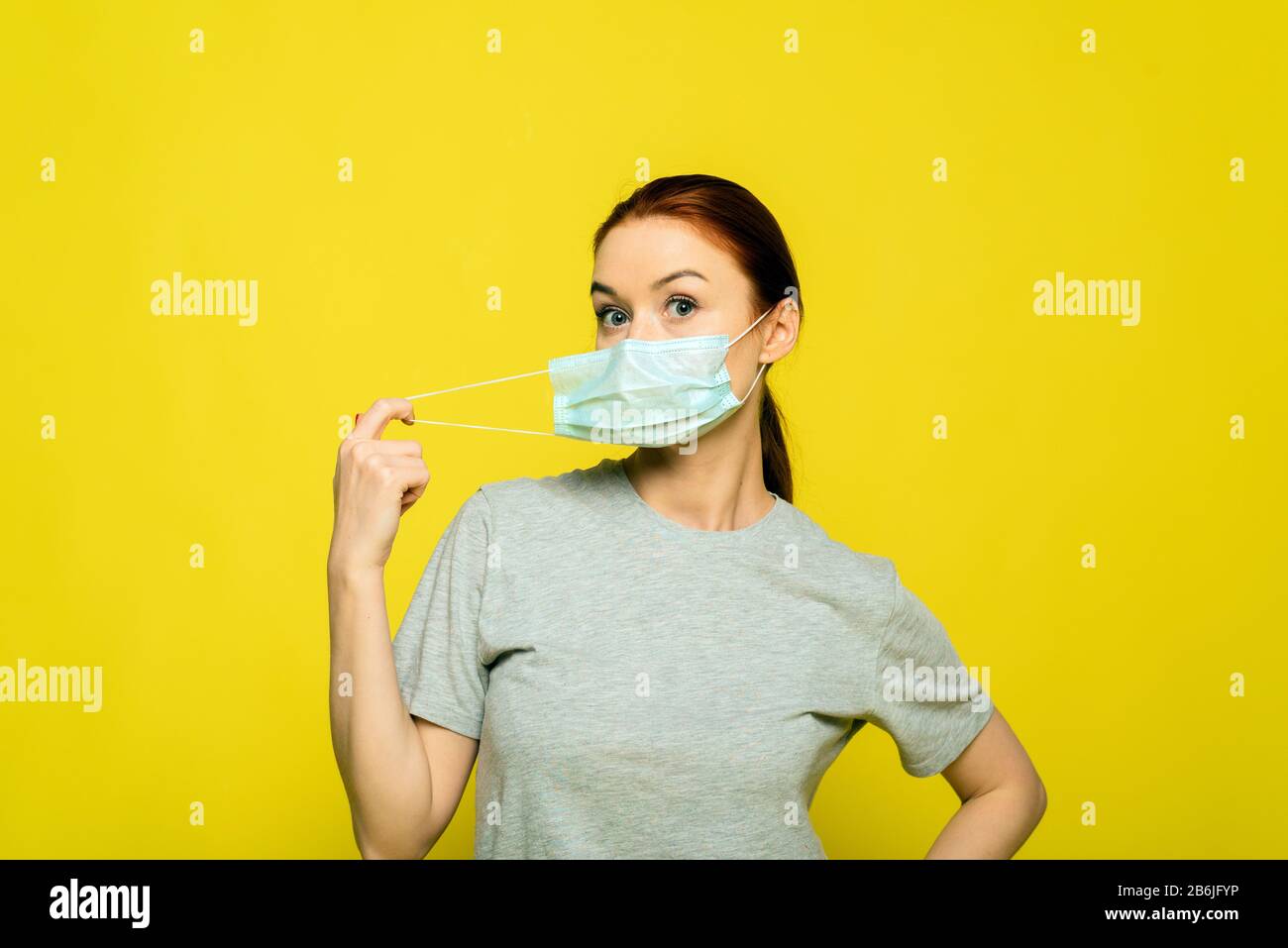 Download Beautiful Woman Put On Medical Mask On A Yellow Background Studio Photo Coronavirus And Covid 19 Concept Studio Portrait Of Young Ill Woman Trying To Put On Medical Flu Mask On Yellow Background PSD Mockup Templates