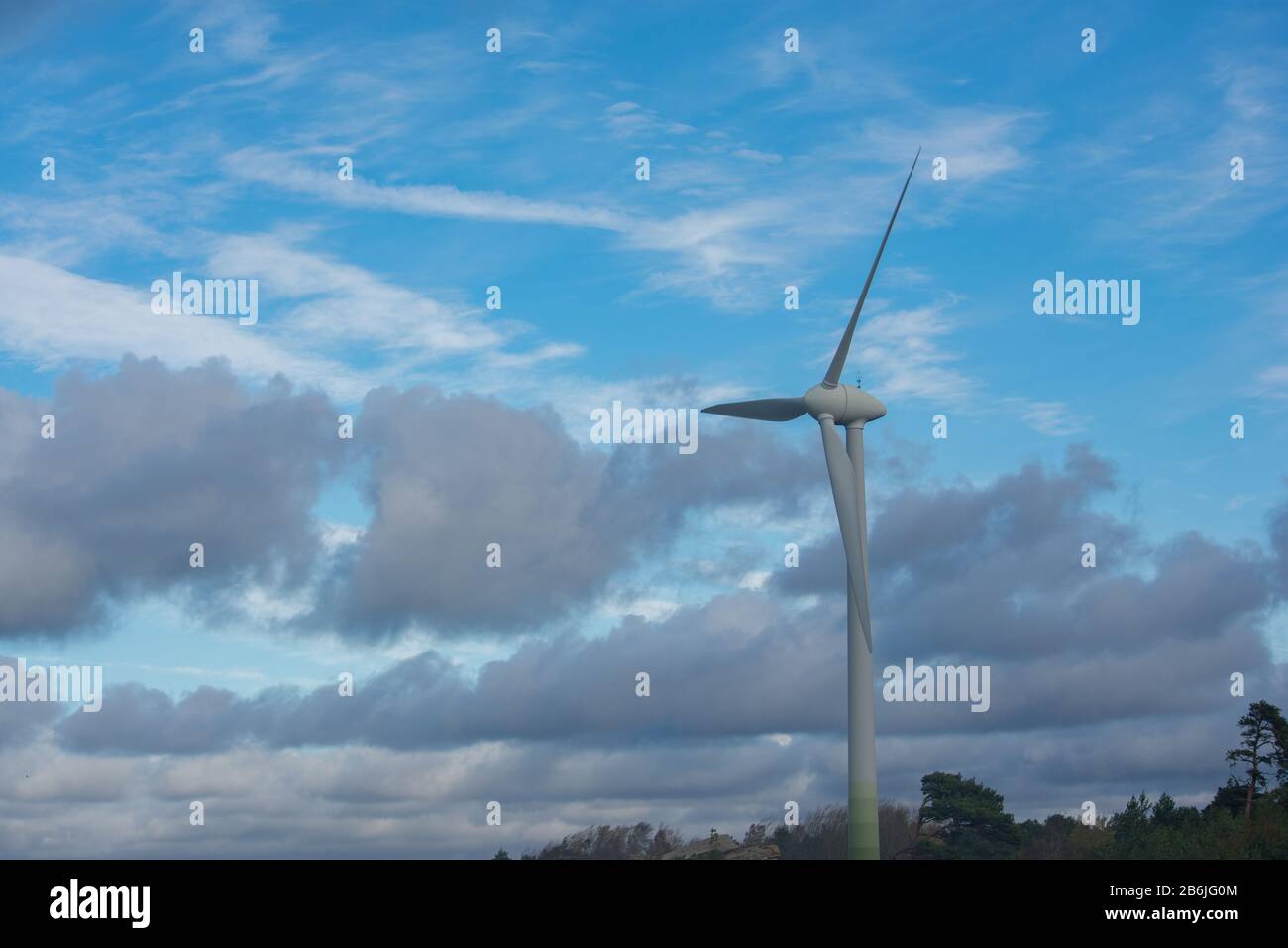 Single large white wind turbine with cloudy blue sky background Stock ...