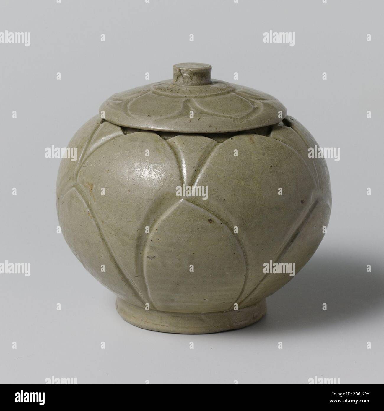 Lidded with incised leaf motifs Dekselpot van steengoed met een bolvormig lichaam, bedekt met een groen glazuur. Op de wand van de pot twee rijen met ingegrifte bloembladmotieven. Op de deksel een band met ingegrifte bladmotieven. Celadon (Yue). Manufacturer : pottenbakker: anoniemPlaats manufacture: China Dating: ca. 900 - ca. 999School / stijl: Song-dynastie (960-1279) Physical kenmerken: steengoed met een groen glazuur Material: steengoed glazuur Techniek: draaiend bewerken / bakken / graveren (inkerven) / glazuren Dimensions: buik: d 12 cm Stock Photo