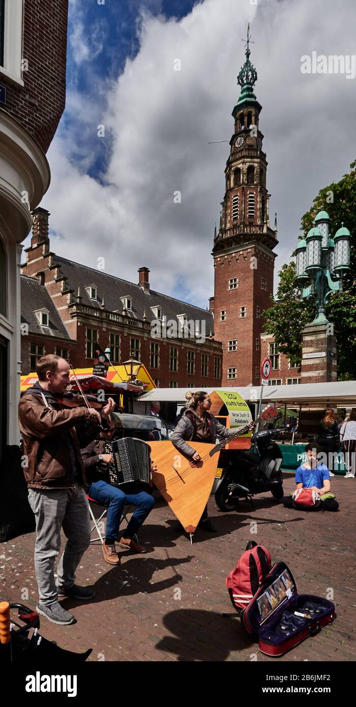 city of Leiden, provincof South Holland, Netherlands, Europe - the street musicians animate the Sunday market in front the renaissance style. clock and bell tower of the City Hall Stock Photo