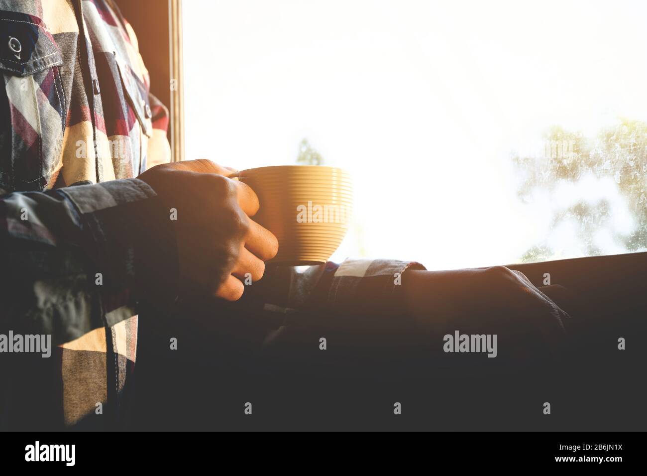 Men hand holding hot cup of coffee or tea in morning sunlight Stock ...