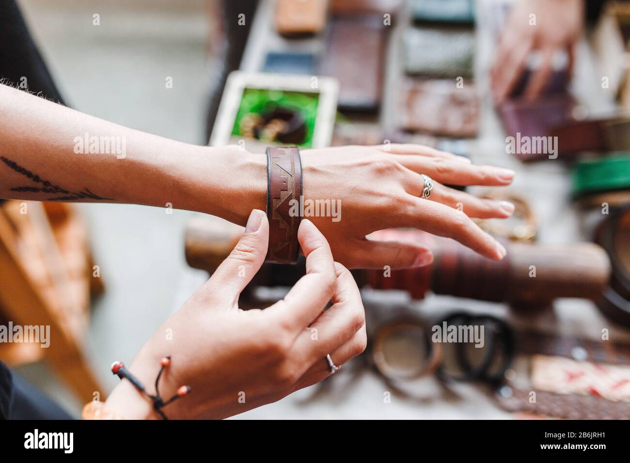 Woman choosing leather jewelry bracelets at the handmade craft market Stock Photo