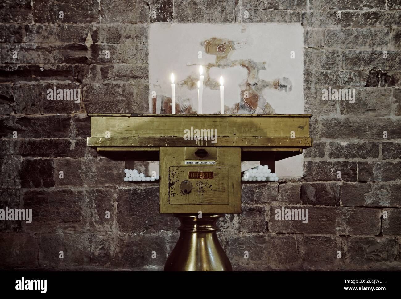 A candle holder in a church with lighted candles and offering box in Italy  Stock Photo - Alamy