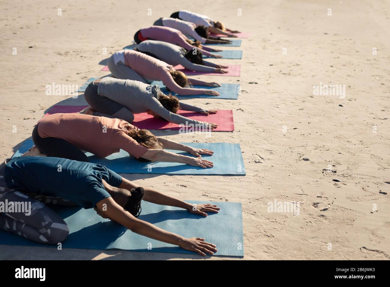Side view of women aligned doing yoga together Stock Photo