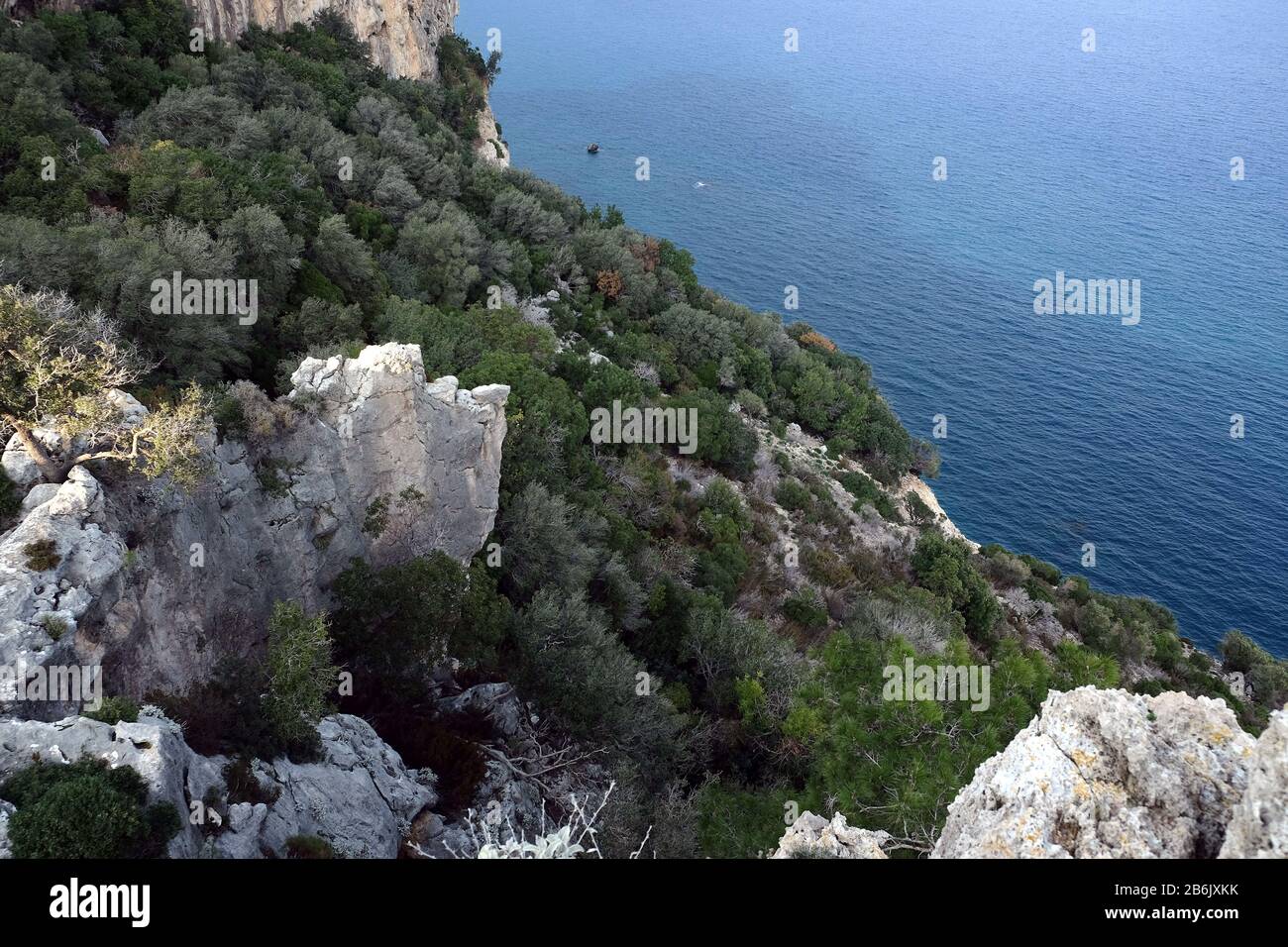 Landscape with high mountains covered with dense southern vegetation and wonderful clean turquoise water Mediterranean sea far below Stock Photo
