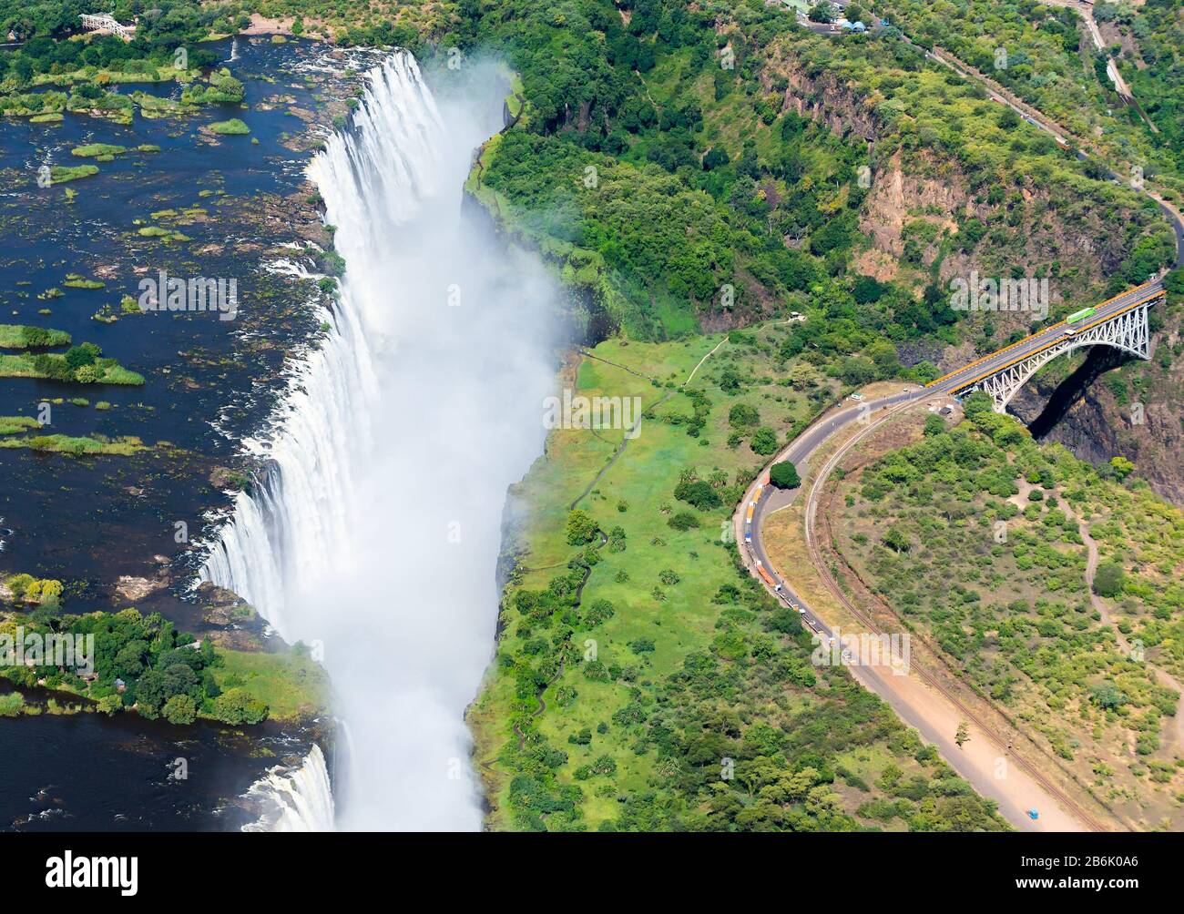 Aerial view of Victoria Falls located Zimbabwe and Zambia border, which can be crossed by bridge. Natural environment with Zambezi River waterfalls. Stock Photo