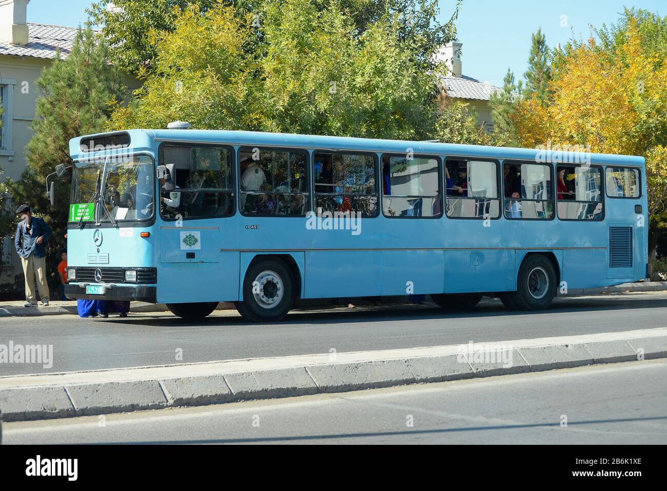 Public transportation bus with local Turkmen people n Kunya Urgench, Turkmenistan. Light blue bus powered by Mercedes Benz. Stock Photo