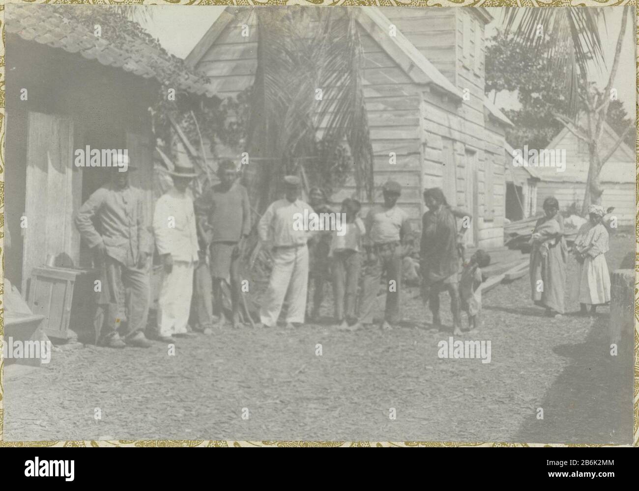 Dorpelingen A group of villagers standing in front of some houses. Part of the album Souvenir de Voyage (Part 1), about the life of the Doijer family in and around the plantation Ma Retraite in Suriname during the years 1906-1913. Manufacturer : Photographer: Hendrik Doijer (attributed to) Place manufacture: Suriname Date: 1906 - 1913 Physical features: gelatin silver print material: paper Technique: gelatin silver print dimensions: photo: h 115 mm × W 166 mm Date: 1906 - 1913 Stock Photo