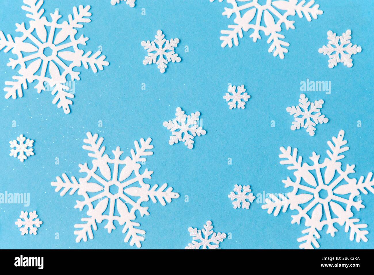 christmas, snow and winter holidays concept - white snowflake decorations on blue background Stock Photo