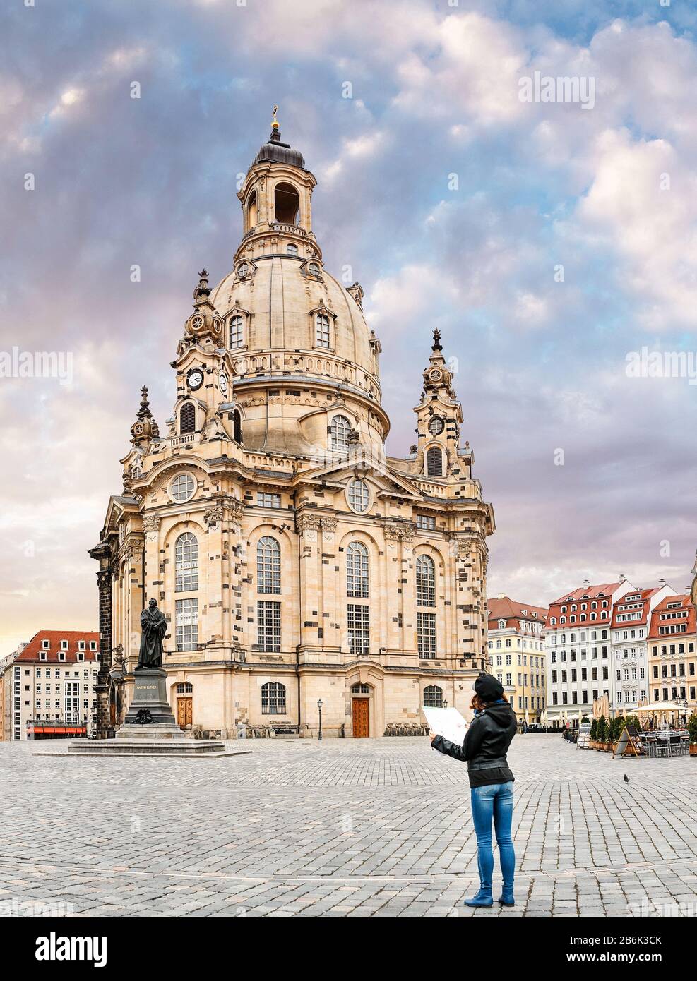 Woman tourist with the map near famous landmark of the Dresden city - Frauenkirche Church of Our Lady Stock Photo