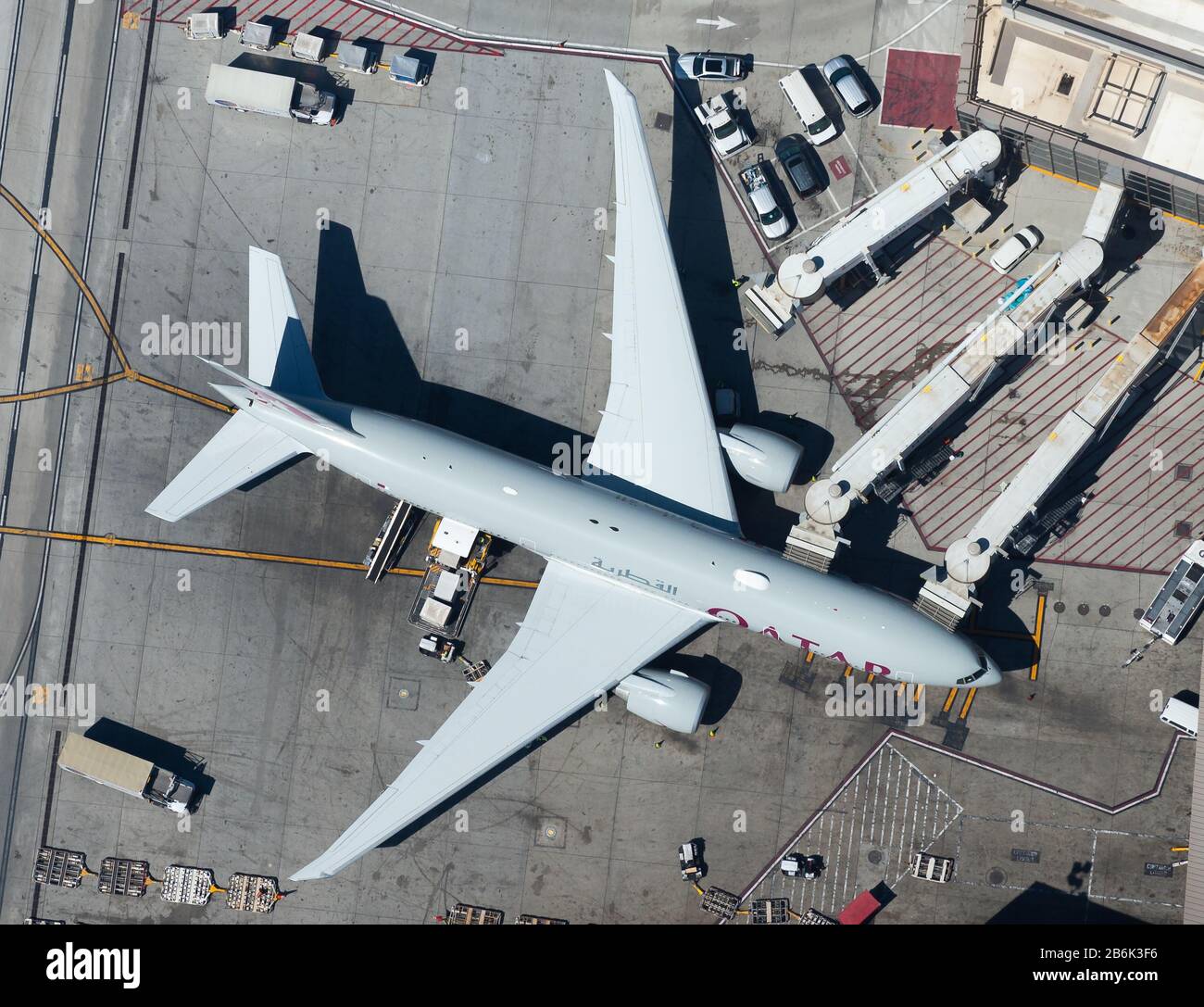Qatar Airways Boeing 777 at Los Angeles (USA) Airport terminal connected to jet bridges for