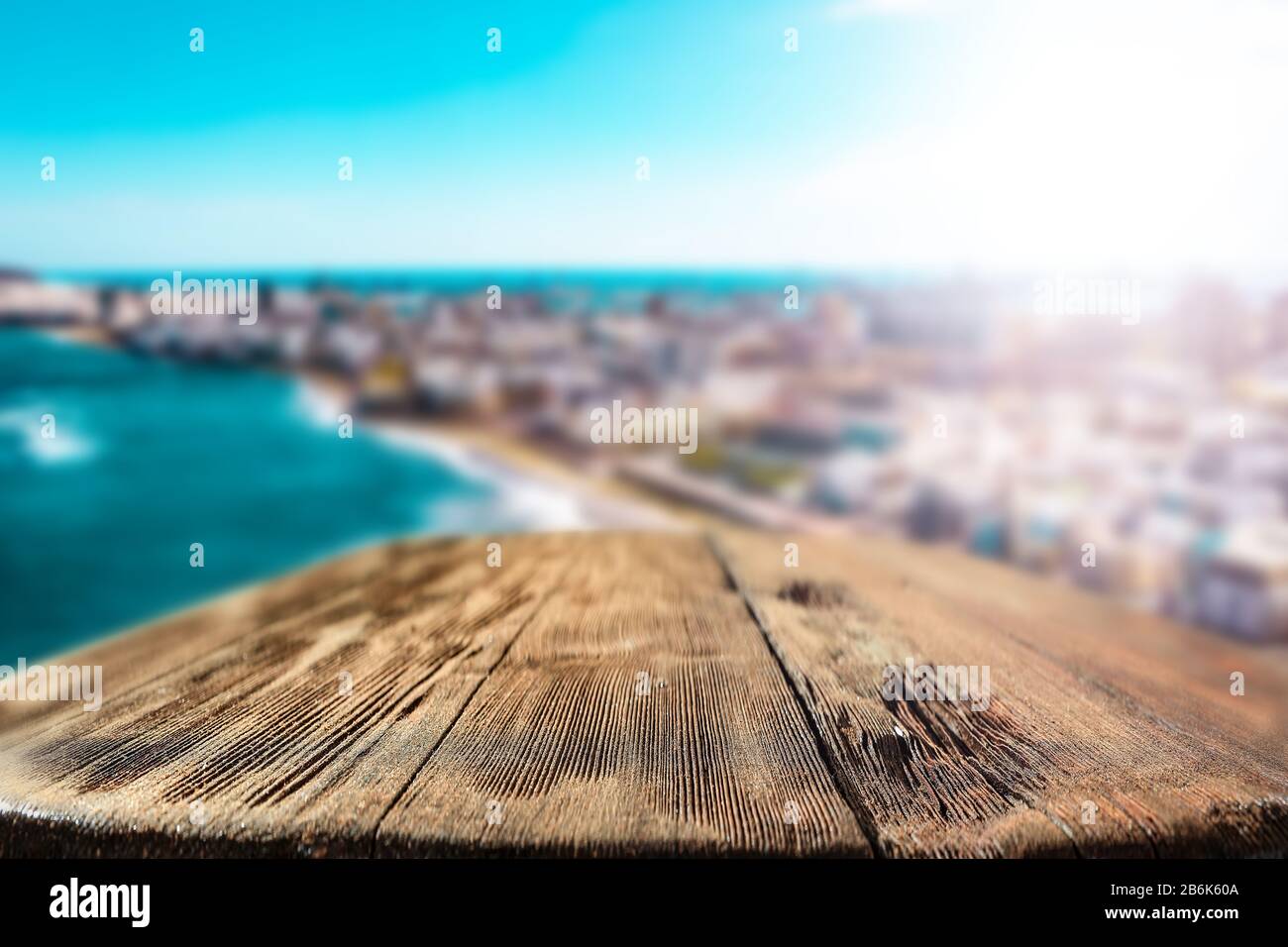 Blurred coastline the turquoise ocean. Wooden table with space for your decoration and advertising products. Happy active sunny summer time and t Stock Photo