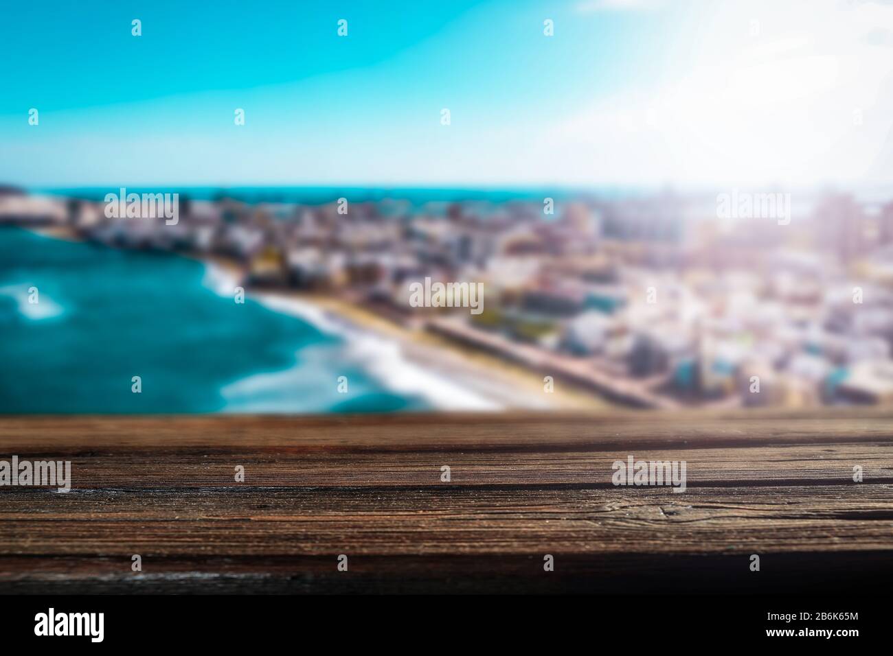 Blurred coastline the turquoise ocean. Wooden table with space for your decoration and advertising products. Happy active sunny summer time and t Stock Photo