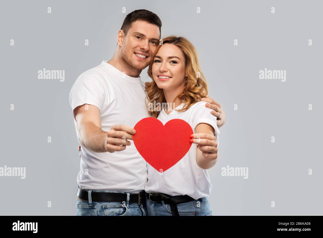 smiling couple holding big red heart Stock Photo