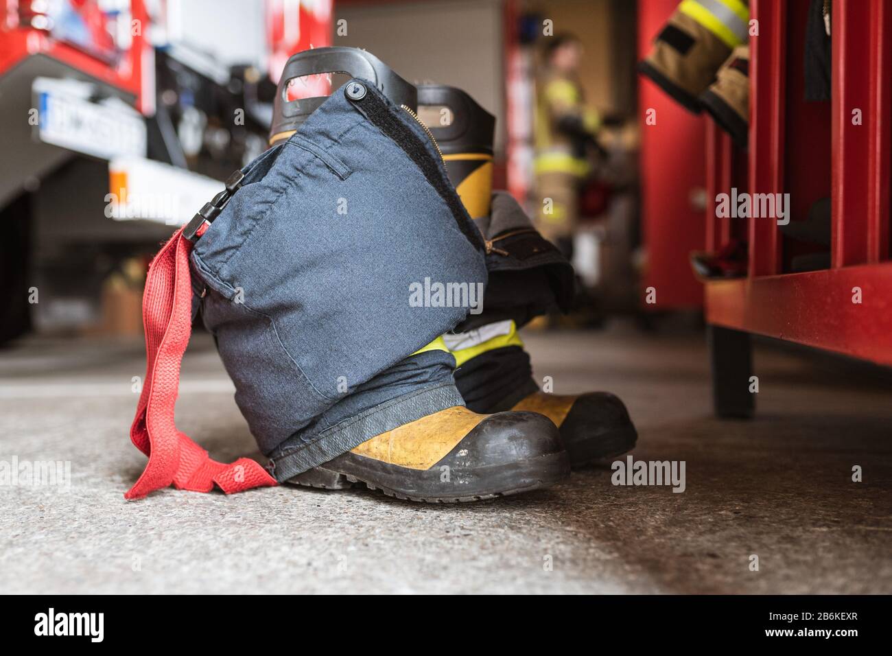 Firefighter's shoes and pants and a wardrobe fire truck and fireman in the background