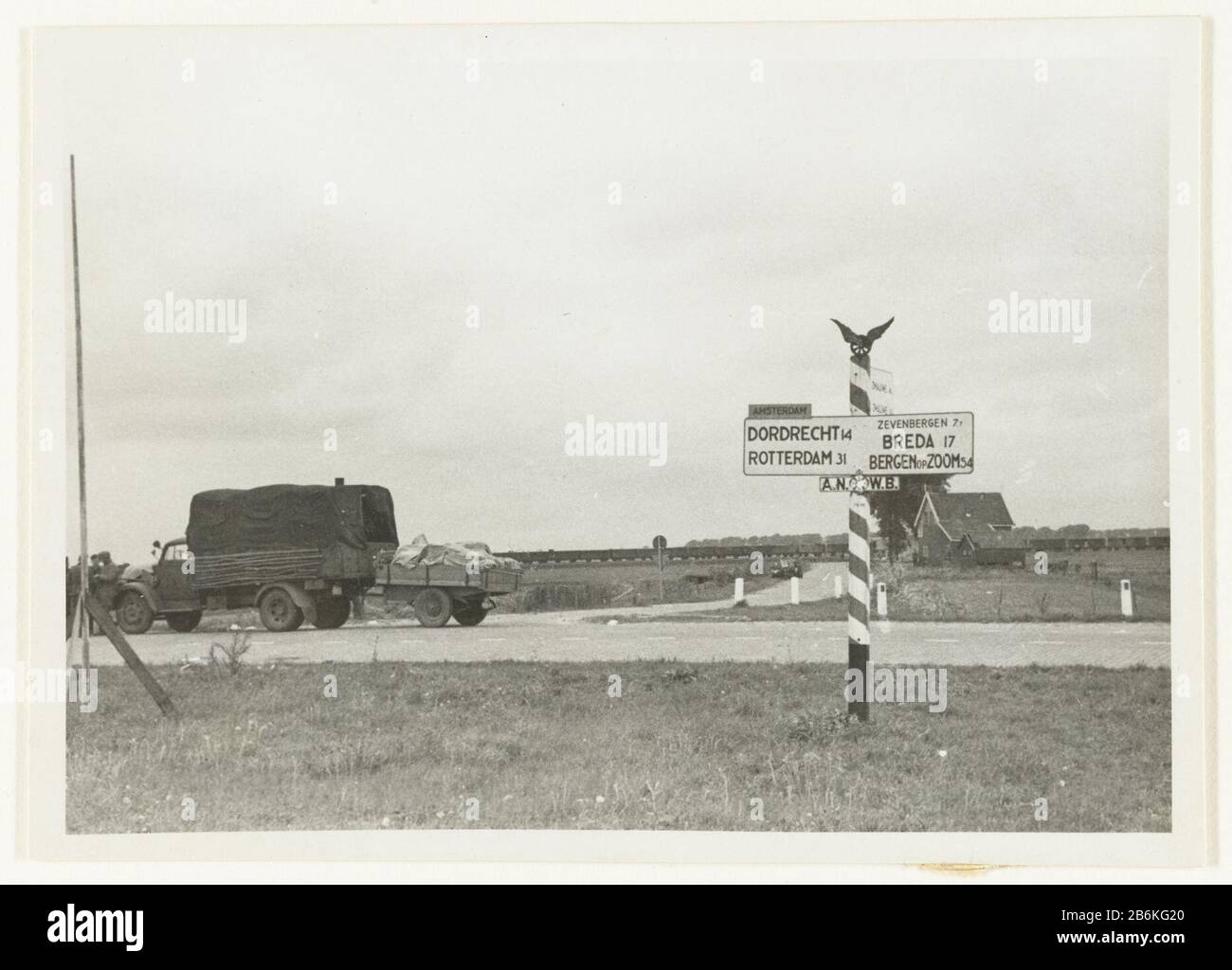 German army truck A truck of the Wehrmacht is on a road with a sign ANWB. Back is: Auf der Strasse nach Auto Rotterdam. Manufacturer : Photographer: anonymous place manufacture: South Holland Date: Jun 1940 - Sep 1940 Physical features: gelatin silver print material: paper Technique: gelatin silver print Dimensions: h 7 cm. B × 10 cm.  Subject: truck, vanmodern forms of military vehiclestroop movements, transportation War II Occupation of Netherlands When: 1940 - 1940 Stock Photo