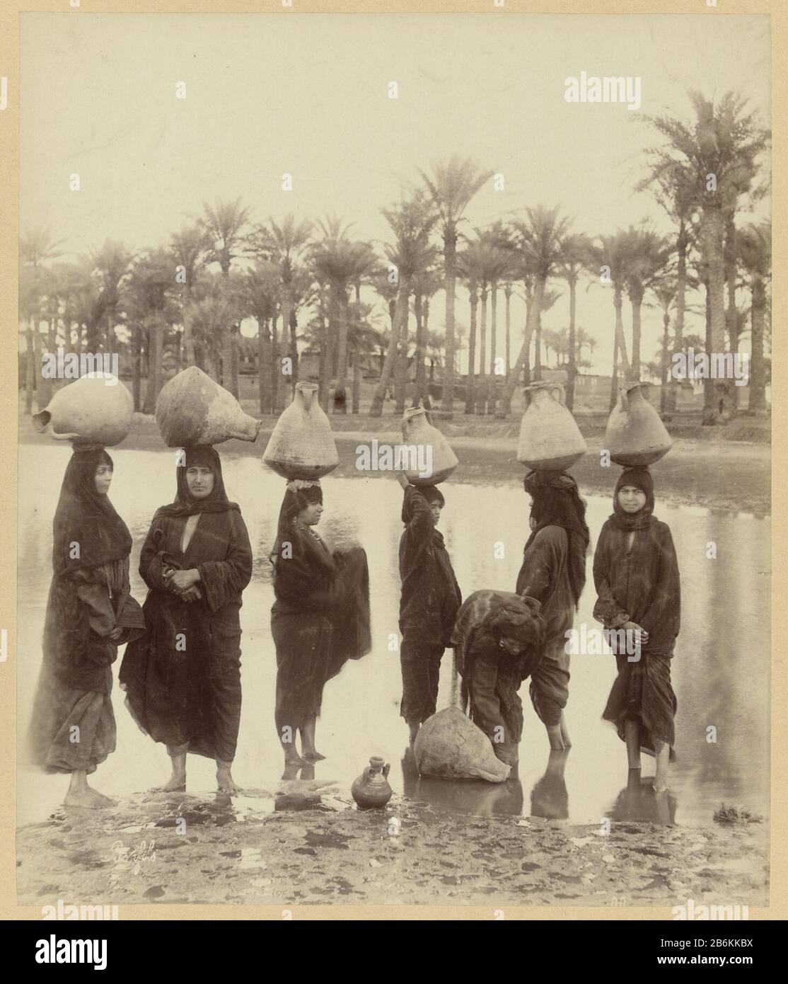 A group of women takes water from the Nile E101 Fellah woman fetching water from the Nile (title object) the photograph is part of the collected photo series from Egypte. Manufacturer  by Richard Polak: photographer: Bonfils (listed object) Place manufacture: Egypt Dating: ca. 1895 - ca. 1915 Physical characteristics: picture on cardboard with onderschrift. Material: photo paper, paper paperboard Technique: albumin pressure dimensions: image: h 278 mm × W 218 mmblad: h 555 mm × W 466 mm Stock Photo