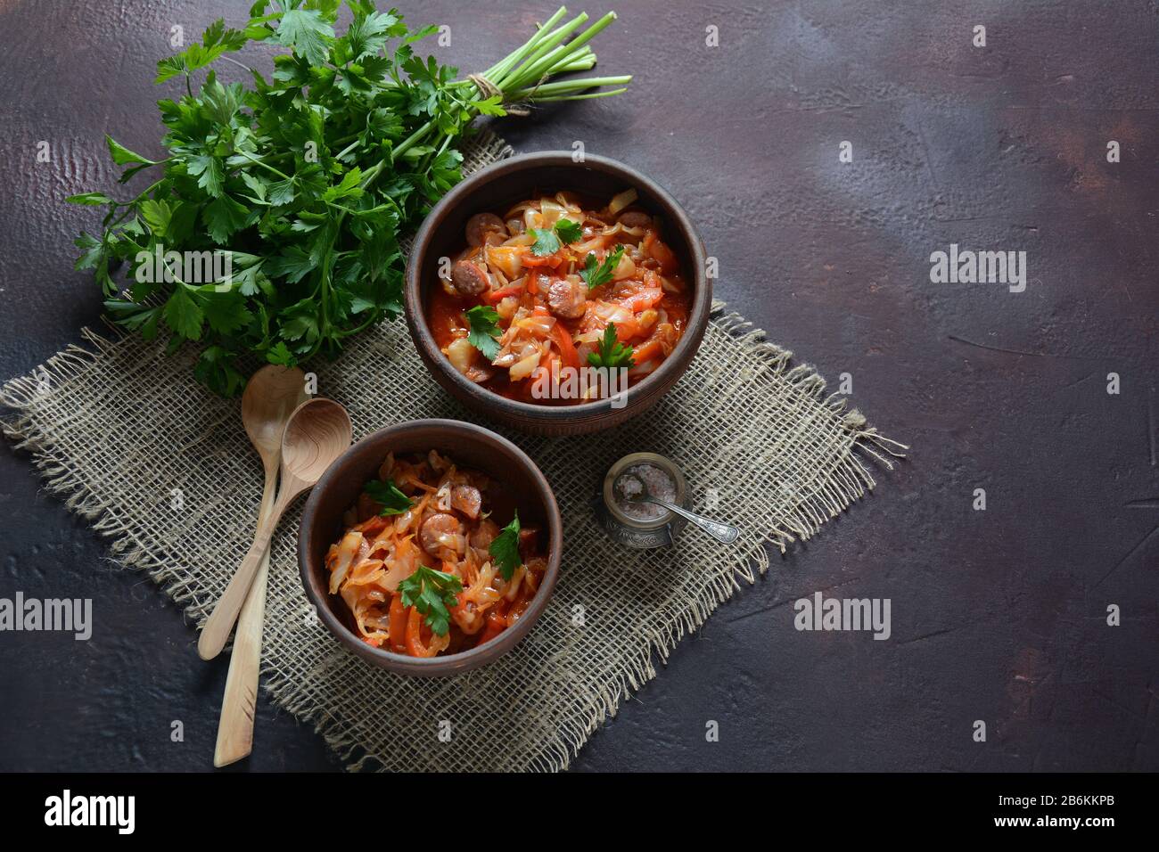 Cabbage stew with grilled sausage in tomato sauce traditional dish of