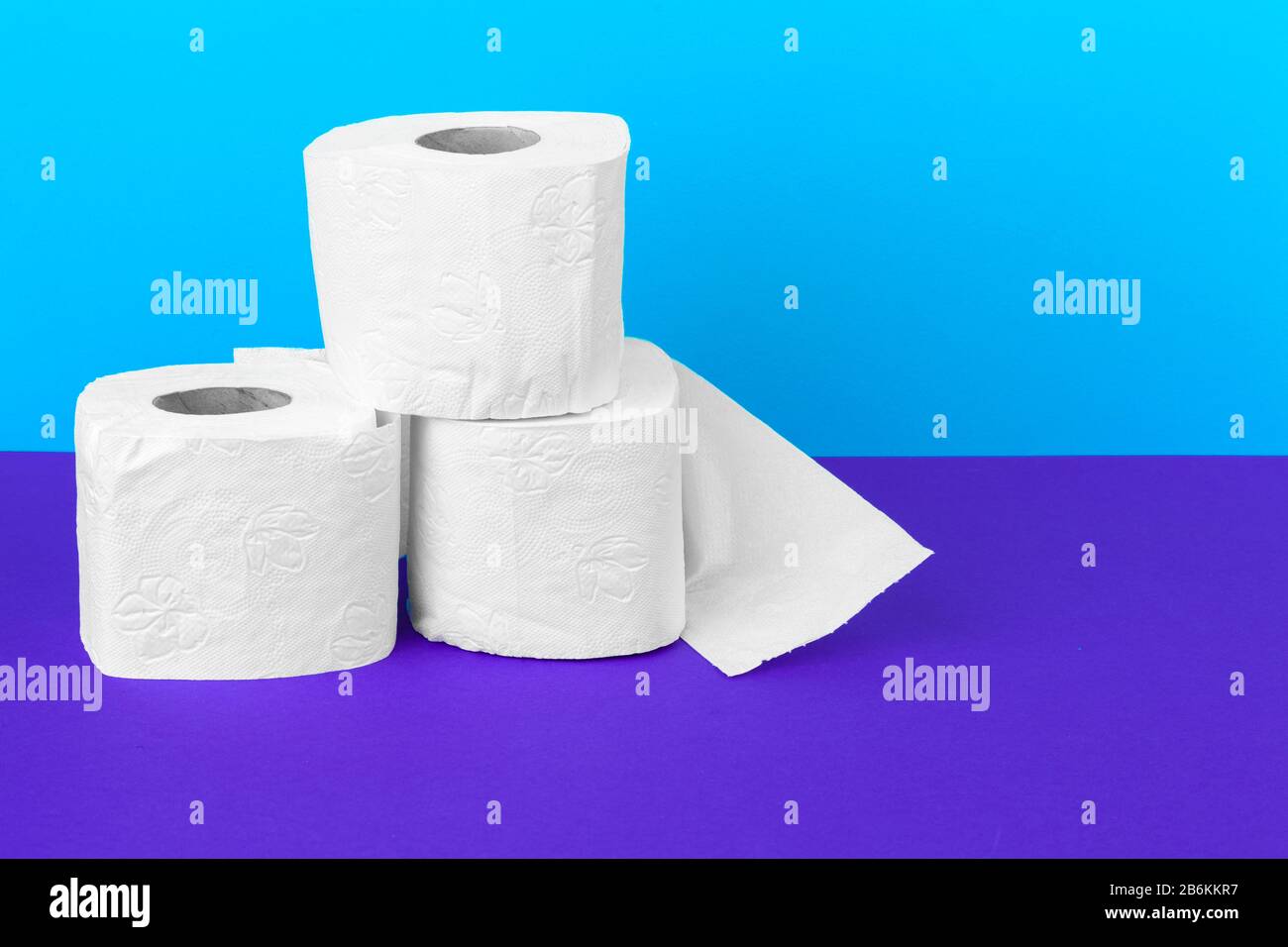 Toilet paper rolls isolated on white table with purple background Stock Photo