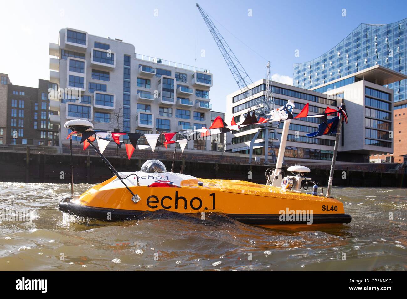 Hamburg, Germany. 11th Mar, 2020. The first autonomous drone for surveying waters, 'echo.1', is on its way in front of the Elbphilharmonie (r) in Hafencity after a naming ceremony in Sandtorhafen harbour. The so-called Autonomous Surface Vehicle (ASV) with its electric drive can be on the road for up to six hours to further improve data on water depths in the Port of Hamburg. Credit: Christian Charisius/dpa/Alamy Live News Stock Photo