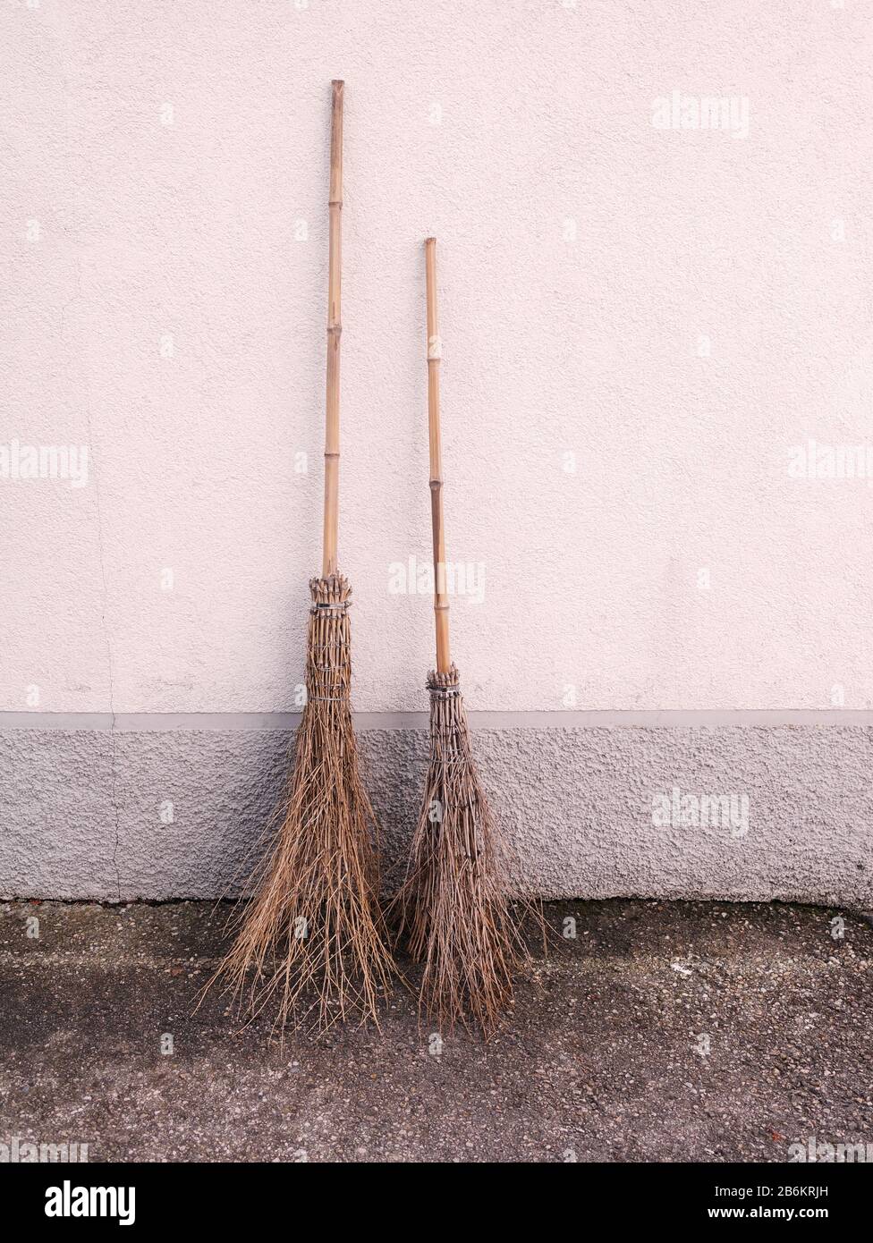 Close-up of two traditional hand made brooms with long handles as well as short handles. Stock Photo