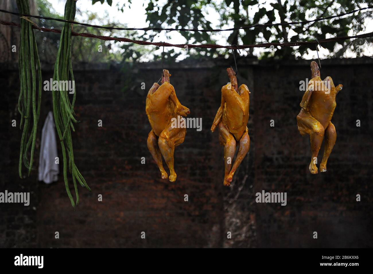 22.02.2014, Yangon, Republic of the Union of Myanmar, Asia - Three freshly prepared chickens hang at a roadside restaurant in the former capital city. Stock Photo