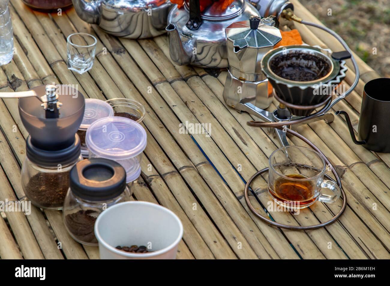 Kit for drip coffee with cup on a bamboo table with coffee beans