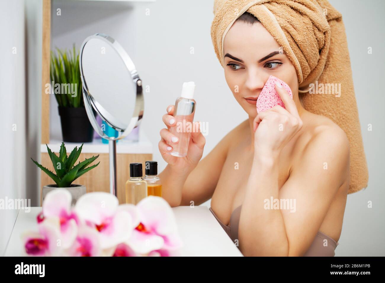 Cute girl puts makeup on the face in the bathroom Stock Photo Alamy