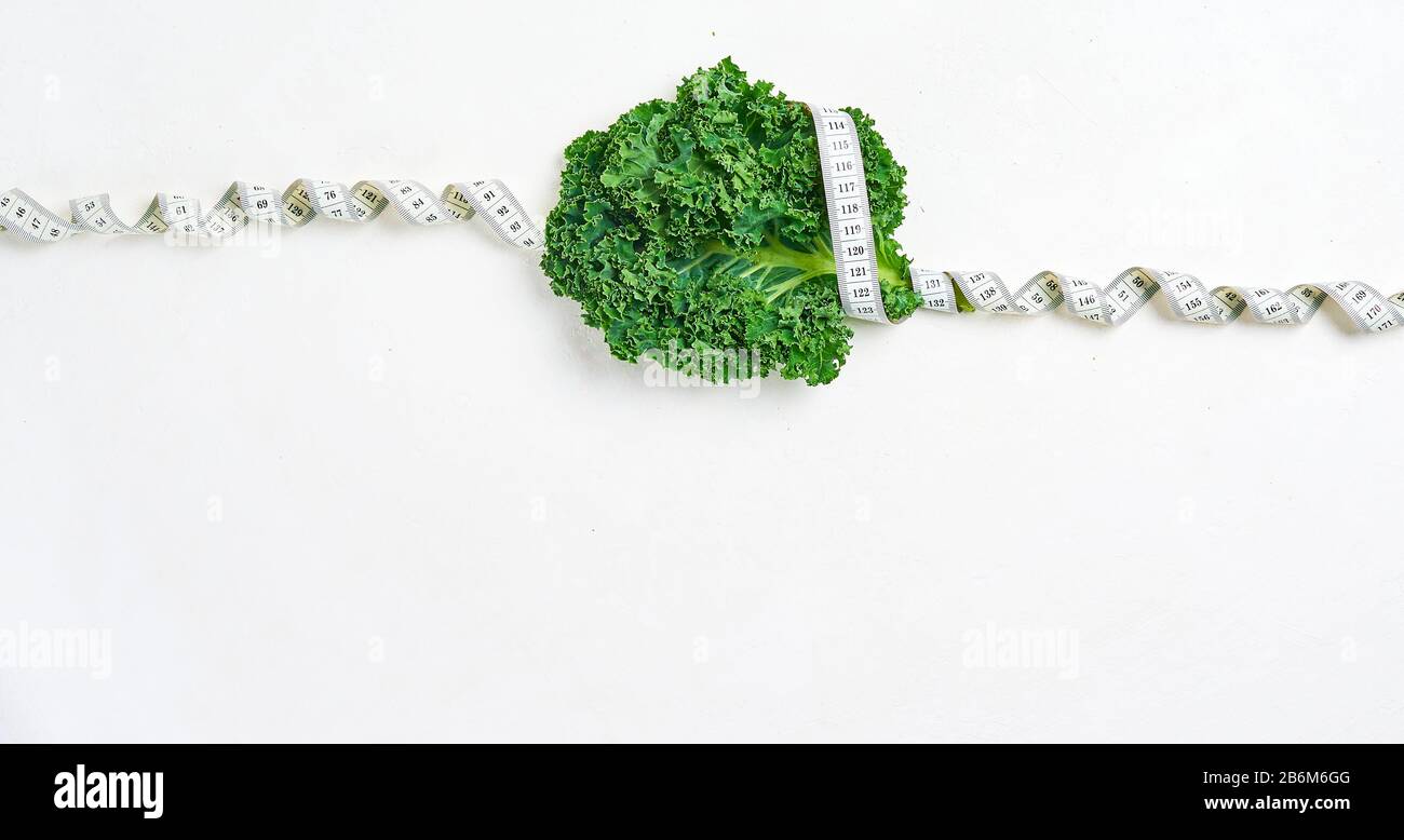 kale wrapped in measuring tape, concept diet, slimming, healthy eating top view Stock Photo