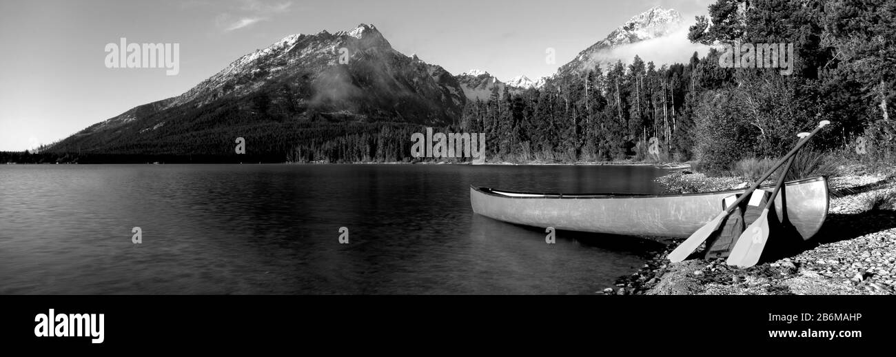 Canoe in lake in front of mountains, Leigh Lake, Rockchuck Peak, Teton Range, Grand Teton National Park, Wyoming, USA Stock Photo