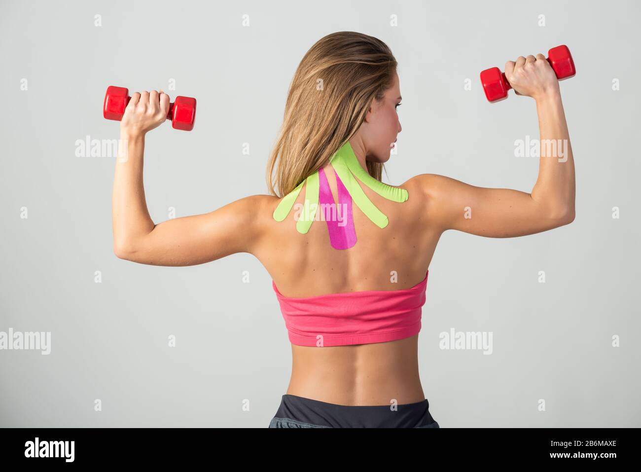 Woman performs exercises with dumbbells with kinesio tapes taped to her neck. Sport and healthy lifestyle concept Stock Photo Alamy