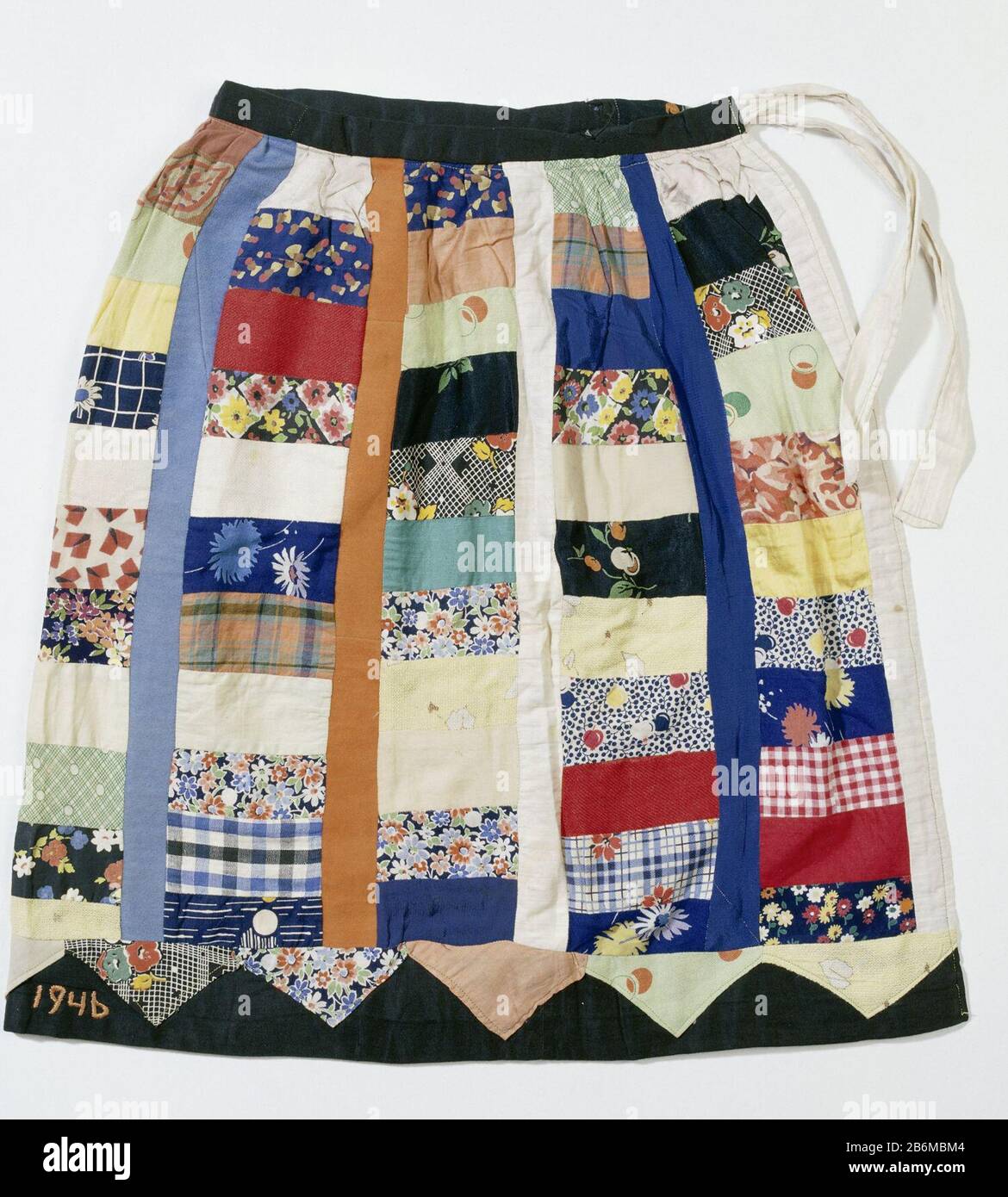 Feestrok, vervaardigd voor de aktie Nationale Feestrok Multicolor wrap  skirt with black waistband and black border on the bottom. There's a ribbon  waistband. The skirt is made up of rectangular patches with