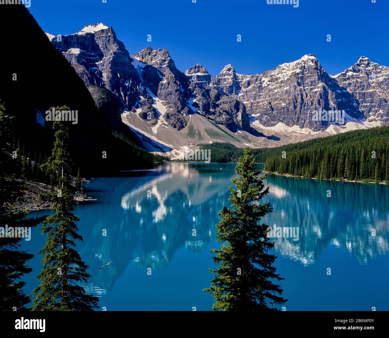 View of Maligne Lake with forest and mountains reflected in water, Banff National Park, Alberta, Canada Stock Photo