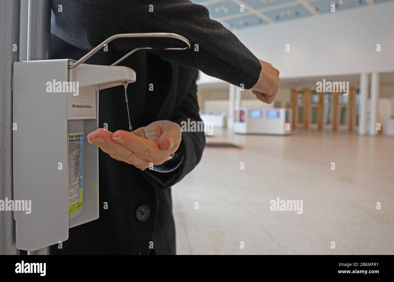 Bonn, Germany. 11th Mar, 2020. A man disinfects his hands in the foyer of the Bundeskunsthalle, pressing down the donor's hanger with his elbow as prescribed. The exhibition 'Wir Kapitalisten - Von Anfang bis Turbo' can be seen from 13 March to 12 July 2020 in the Bundeskunsthalle. Credit: Oliver Berg/dpa/Alamy Live News Stock Photo