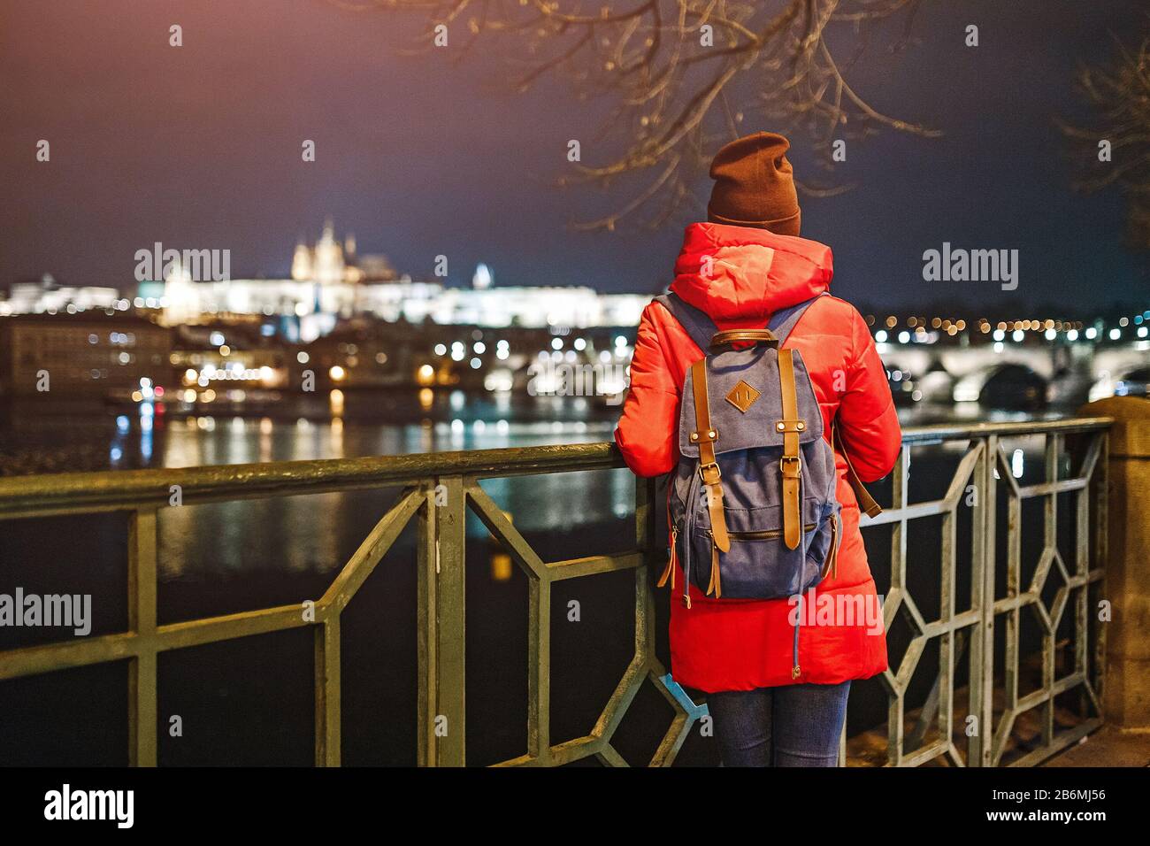 Back view of a hipster girl with backpack walking on Prague city street ...