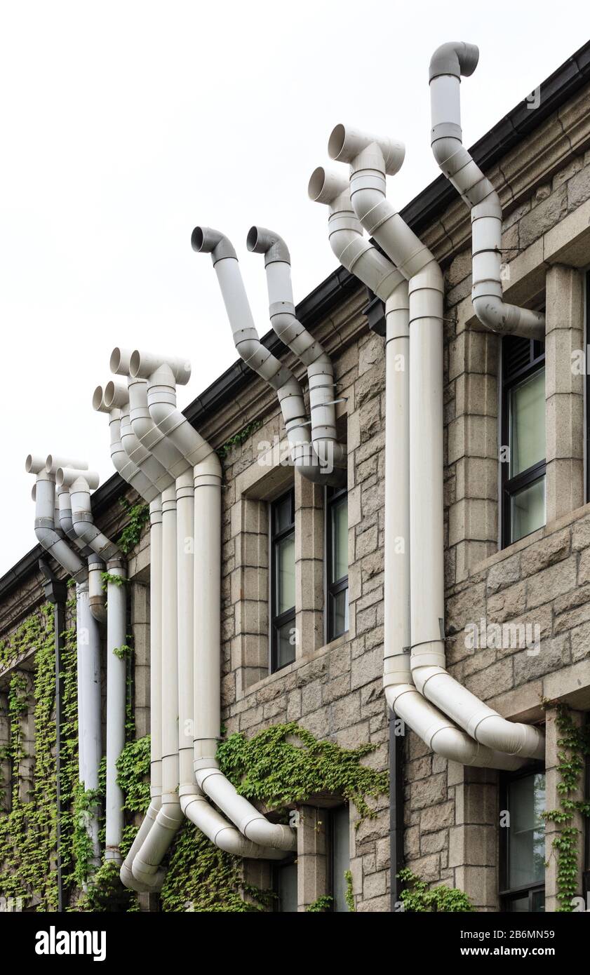 Facade of an old building with plastic ventilation exhaust pipes Stock