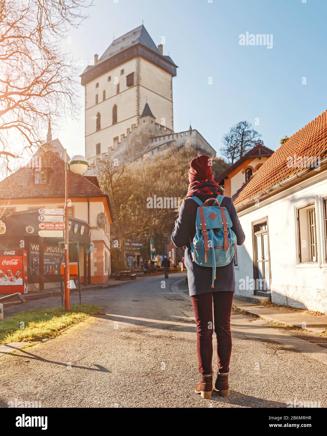 woman-traveler-with-backpack-looking-at-the-medieval-gothic-castle-karlstejn-in-czech-reoublic