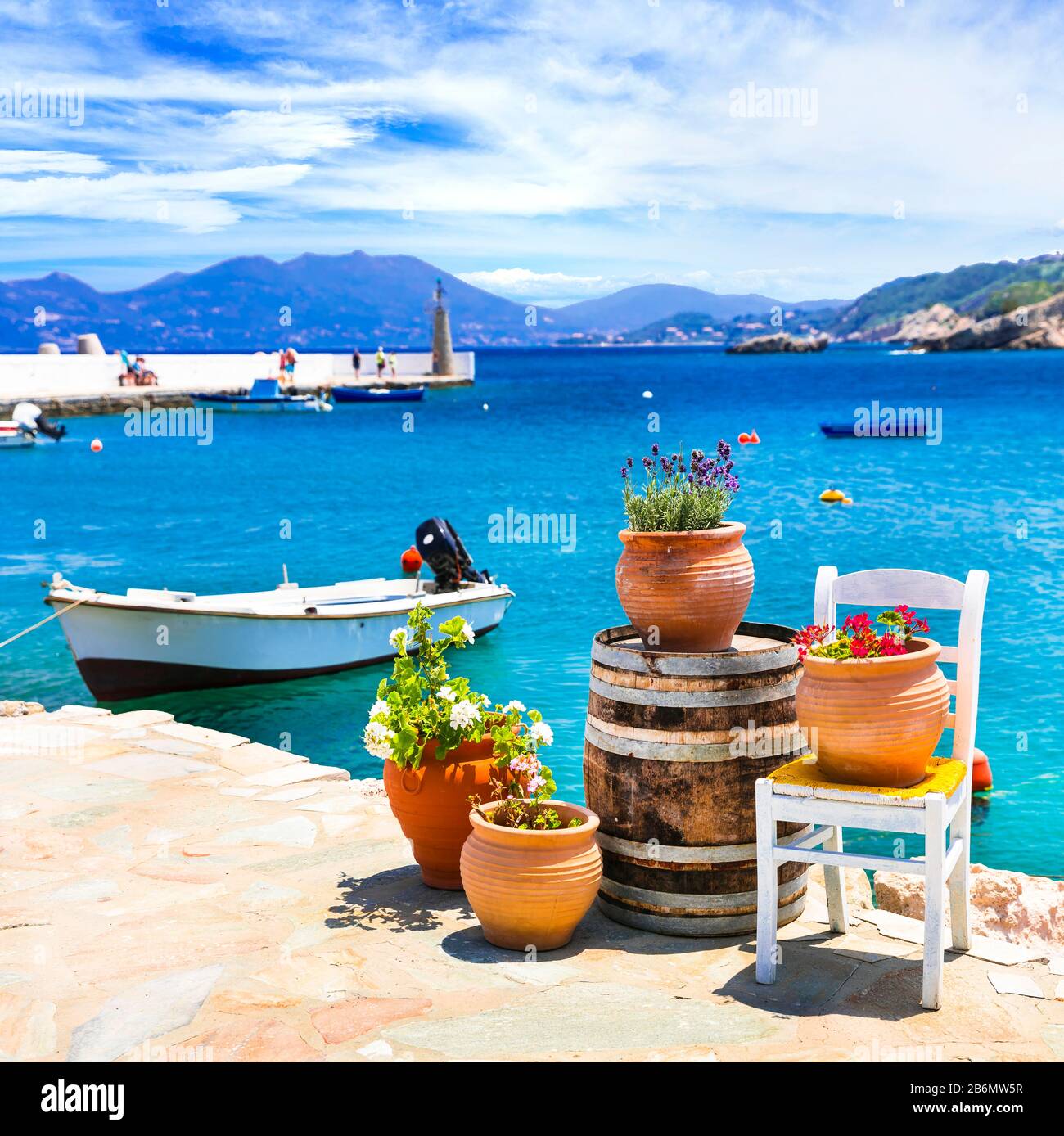 Traditional kokkari village ,view with turquoise sea,chair ,flowers and mountains,Samos ,Greece. Stock Photo