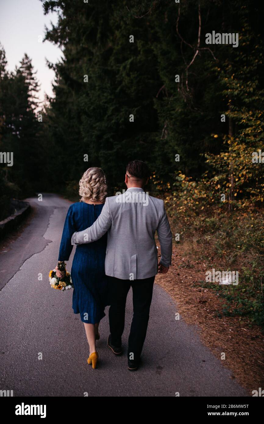 Bride Is In A Blue Wedding Dress With A Bouquet Of Sunflowers In Hand Groom In A Suit Walking Together Beautiful Couple Having A Romantic Moment Stock Photo Alamy