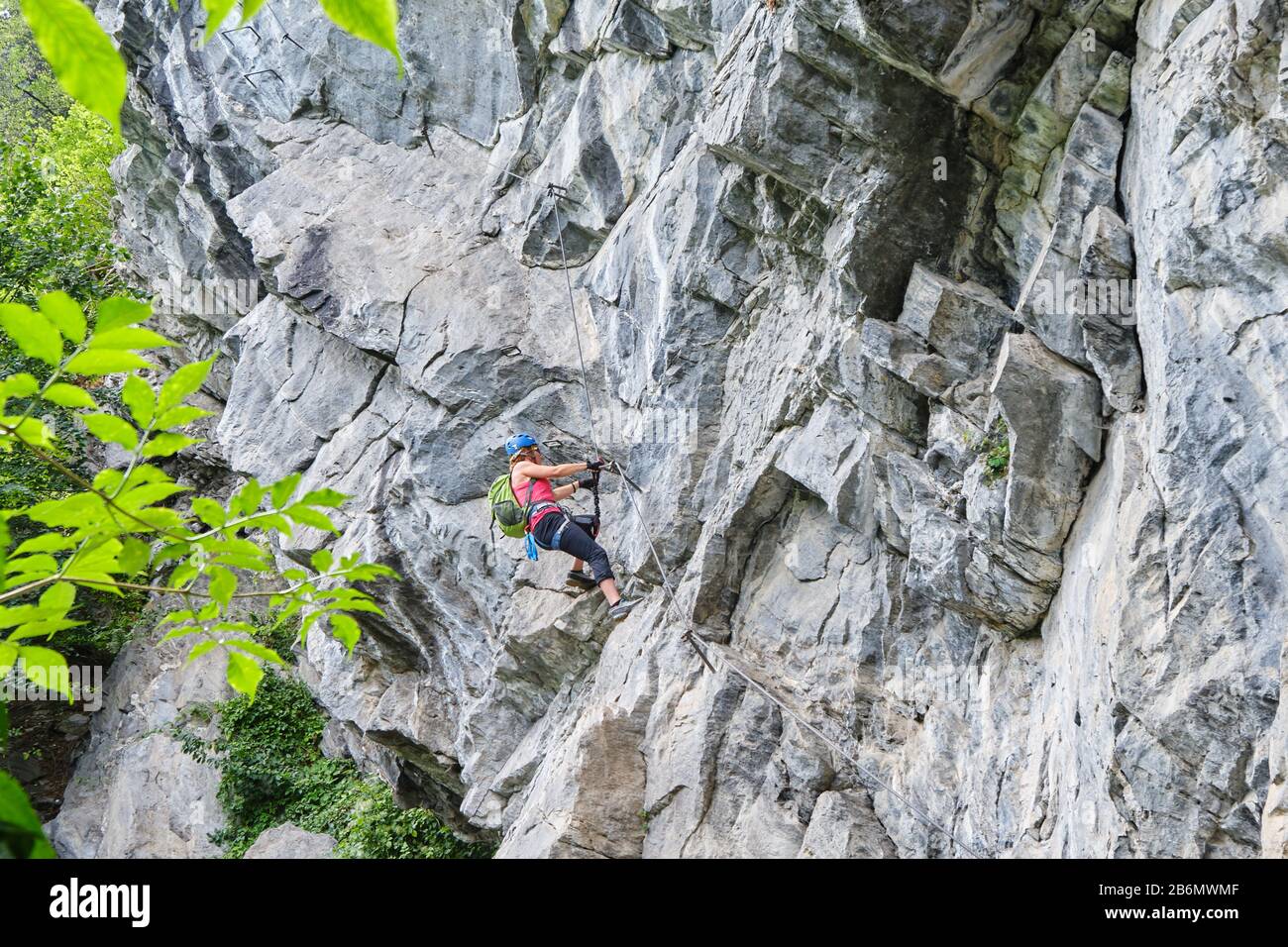 Woman climbing impressive overhanging rock formations on a via ferrata route called Zimmereben (rated D/E - difficult), near Mayrhofen, Zillertal vall Stock Photo